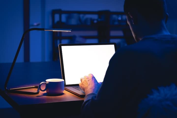Candidato estudando para concursos de madrugada em frente à uma tela de computador